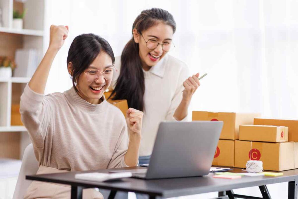 Two women cheering as they make a sale