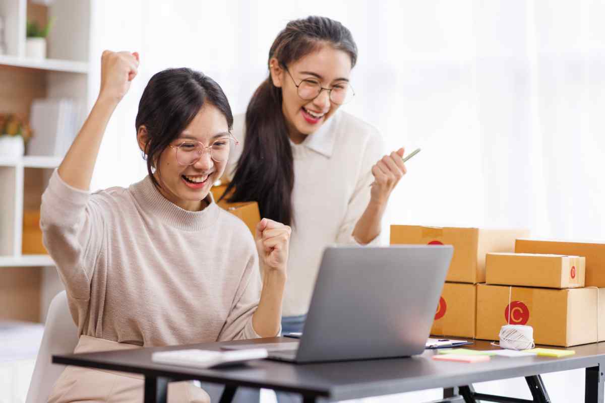 Two women cheering as they make a sale