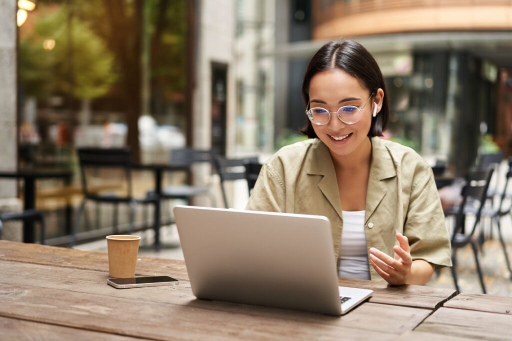 A woman working on her laptop outside.
